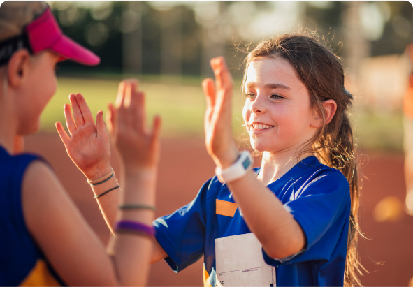 Niños con uniforme deportivo celebrando al aire libre