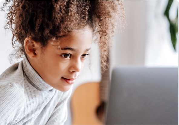 Niña mirando de cerca la pantalla de una computadora portátil